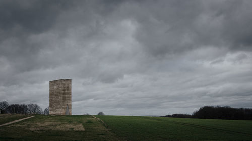 Rustic modern chapel by peter zumthor against cloudy sky