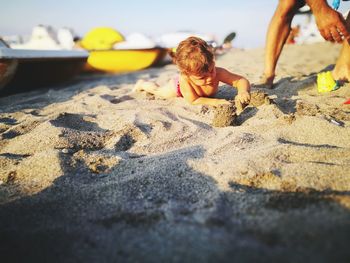 Boy playing with toy on sand at beach