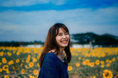 Portrait of smiling woman standing on field