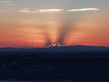 Silhouette landscape against sky during sunset