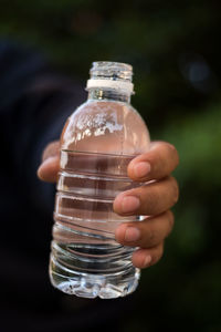Cropped hand of man holding water bottle
