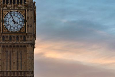 Clock tower against cloudy sky during sunset