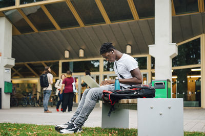 Male college student e-learning on laptop in campus