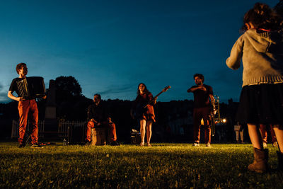 People standing on field against sky