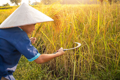 Midsection of man holding umbrella on field