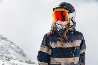 Portrait of sportswoman wearing helmet and mask looking away enjoying frosty day perfect day for