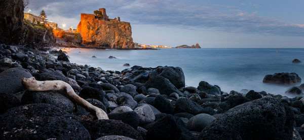 Rocks on beach against sky