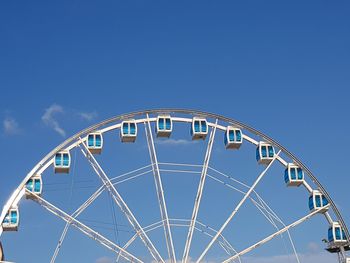 Low angle view of ferris wheel against blue sky