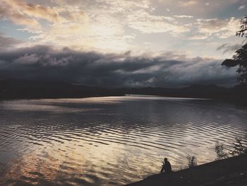 Scenic view of beach against dramatic sky