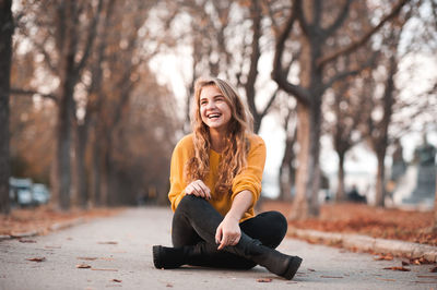 Happy young woman sitting in park