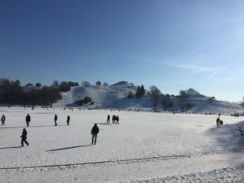 People on landscape against sky during winter