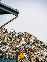 Stack of garbage on metal against sky