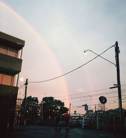 Low angle view of rainbow over buildings in city