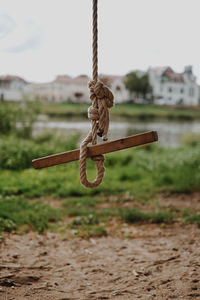Close-up of rope tied on metal chain swing