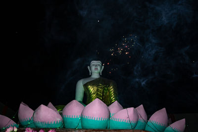 Sculpture of illuminated buddha statue at night