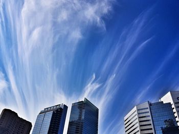 Low angle view of modern buildings against blue sky