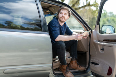 Person holding trail map sitting in van looking off frame