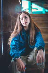 Portrait of young woman sitting on staircase