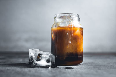 Close-up of iced tea in glass jar on table