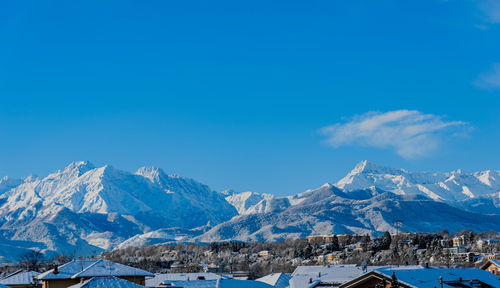 Scenic view of snowcapped mountains against blue sky