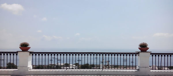 Scenic view of sea seen through railing against sky