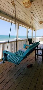 Rear view of man relaxing on chair at beach