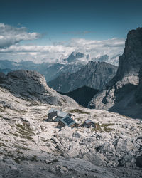 Scenic view of houses on land against mountains and sky