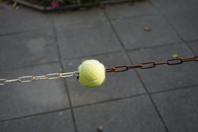 Close-up of yellow ball on  chain