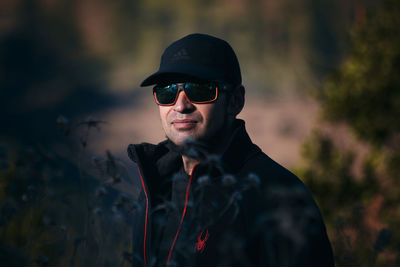 Portrait of young man wearing sunglasses standing outdoors