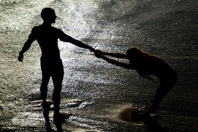 Silhouette of children playing on sand