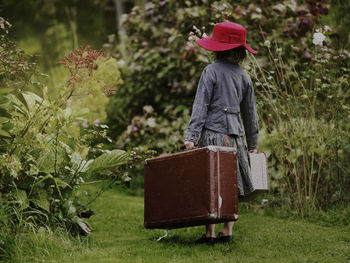 Girl with suitcases in garden, varmdo, uppland, sweden