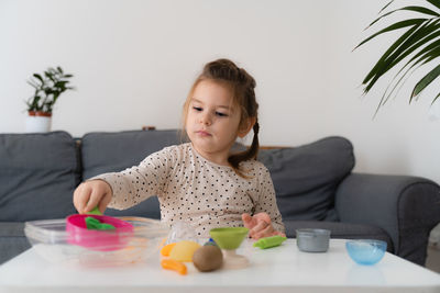 Cute girl playing with clay at home