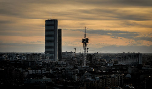 View of cityscape against cloudy sky