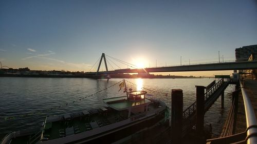 Bridge over river against sky during sunset