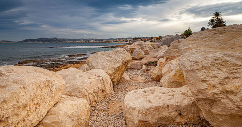 Panoramic view of rocks on beach against sky