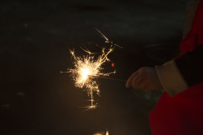 Close-up of hand holding sparkler at night