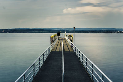 Pier over lake against sky