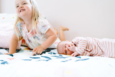 Closeup portrait of two sister laying together on a bed