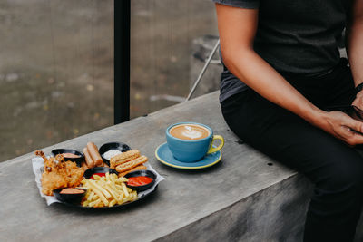 Midsection of man sitting on table at restaurant