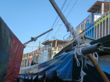 Low angle view of clothes hanging on clothesline against buildings