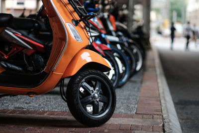 Close-up of motorcycle parked on street pavement