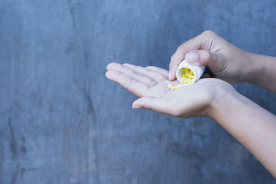 Cropped hands of woman holding yellow flower