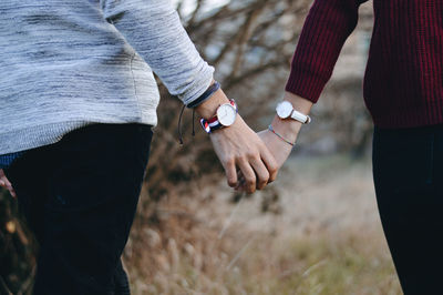 Midsection of couple holding hands