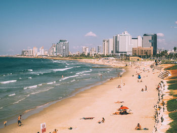 High angle view of people on beach in city against sky