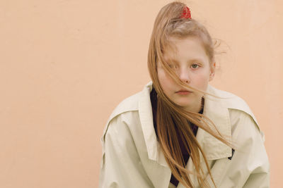 Portrait of girl standing against wall