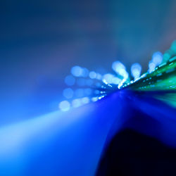 Close-up of wet blue illuminated lights at night