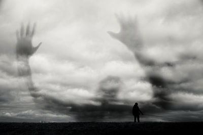 Silhouette man standing on field against sky