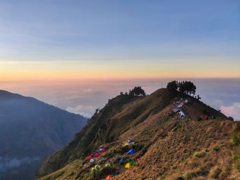 Tents on mountain against sky during sunset