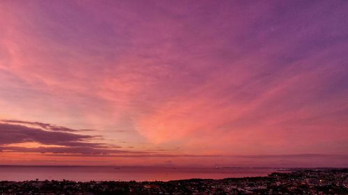 Scenic view of sea against dramatic sky during sunset