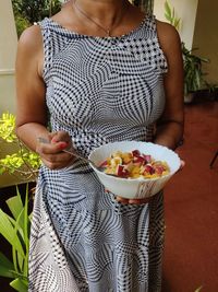 Midsection of woman holding bowl